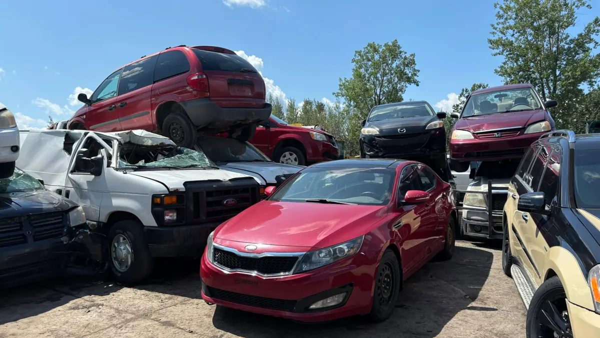 Red Kia, Ford pickup and Dodge minivans in the Saint-Jean-sur-Richelieu scrap yard