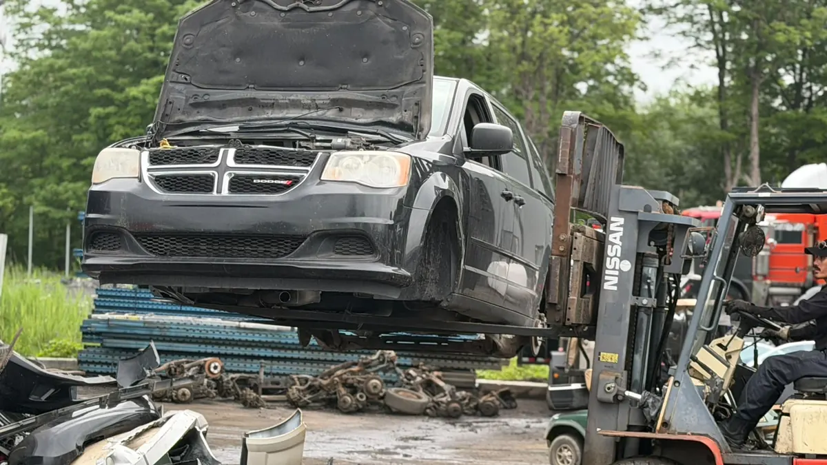 Chariot élévateur qui déplace une Dodge Grand Caravan dans la cour de Recyclage Auto St-Jean