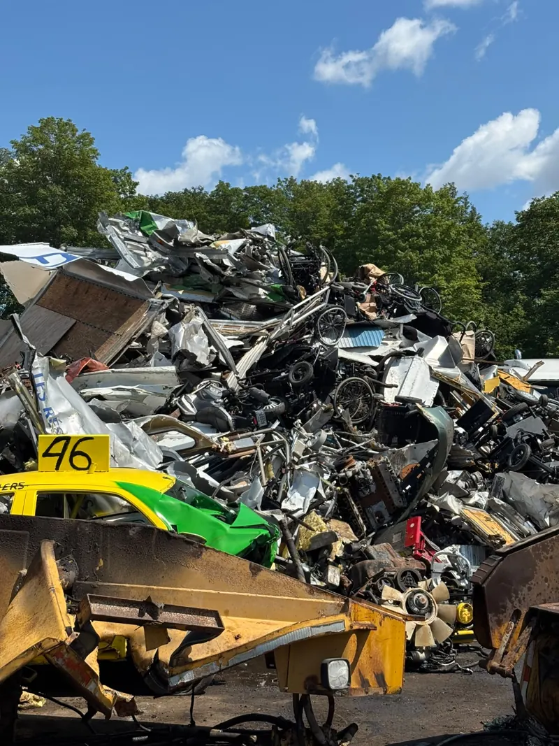 Chargeuse devant une pile de ferraille métallique au dépôt de Recyclage Auto St-Jean