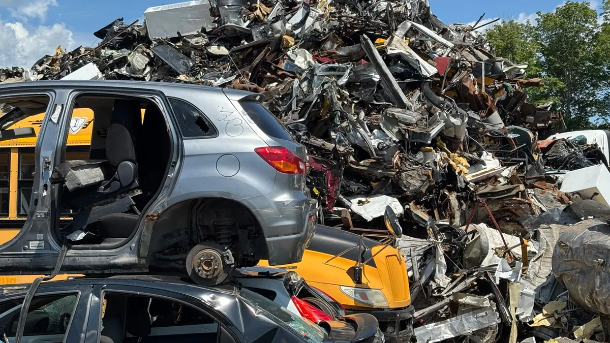 Montagne de ferraille automobile et carcasses de véhicules démontés au centre de recyclage